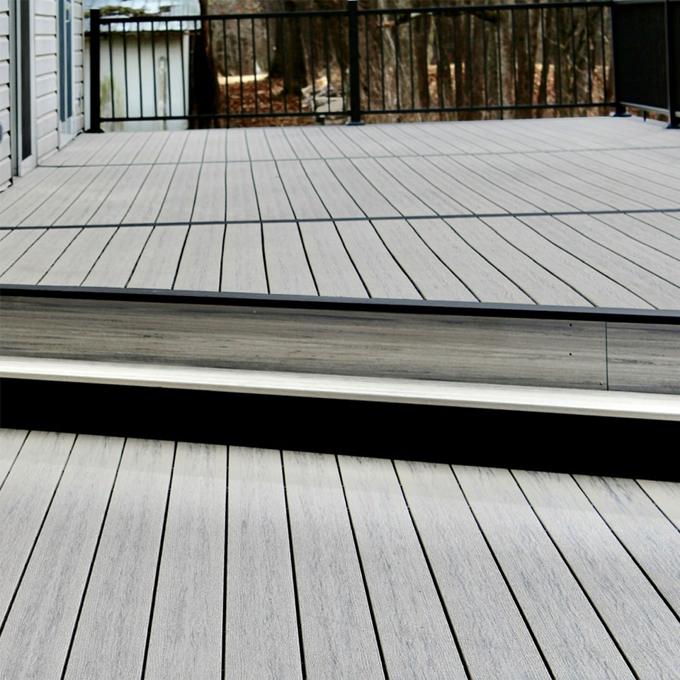 person drilling a screw into decking material