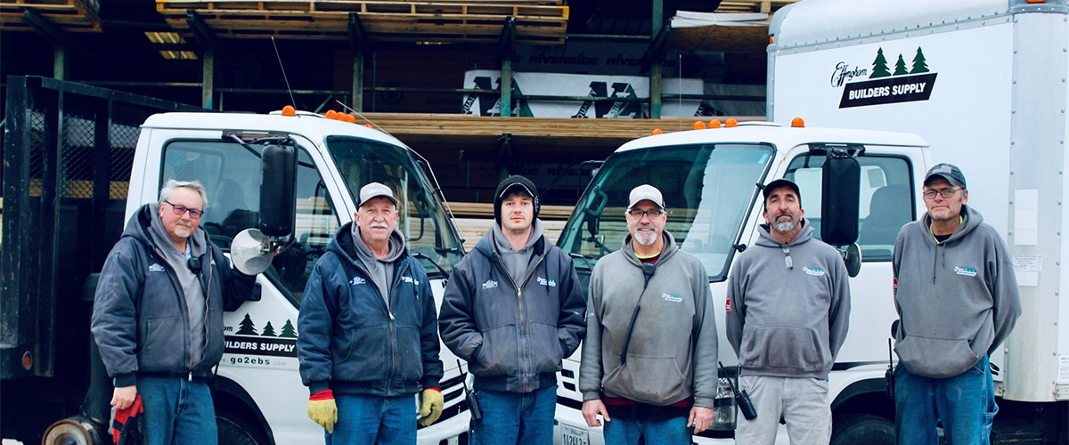our delivery crew standing in front of 2 of our delivery trucks
