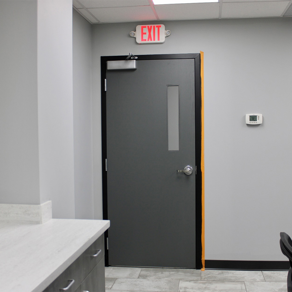 architectural door with an illuminated exit sign above it